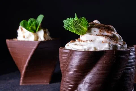 Cups printed on a 3D printer with chocolate, whipped cream and mint leaves Stock Photos