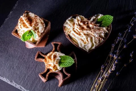 Cups printed on a 3D printer with chocolate, whipped cream and mint leaves Foto stock