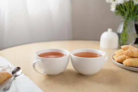 Cups of tea and sweets on the table at home Stock Photos
