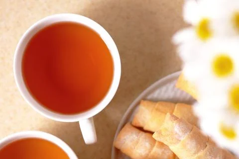 Cups of tea and sweets on the table at home Stock Photos