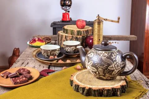 Cups of tea on old wooden table, with apples and nuts Stock Photos