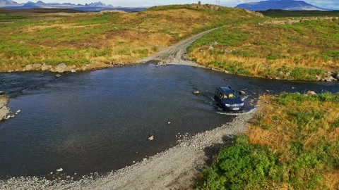 Cur almost stuck in water somewhere off road in Iceland Stock Footage 233035666