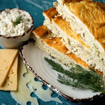 Curd pie with dill. Stack of cut pieces on plate. Homemade pie with cottage Stock Photos