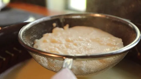 Curdled milk being strained through cheesecloth, separating curds and whey in 스톡 동영상 319981665