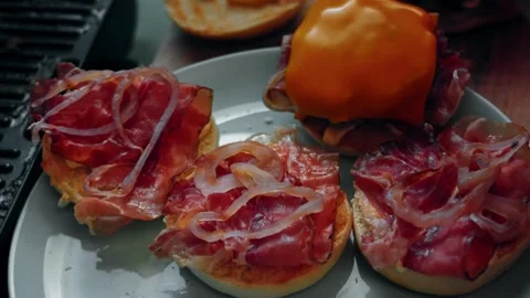 Cured meat layered over open Halloween burger buns, 4K Stock Footage 341117702