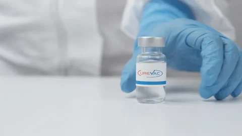 CureVac vial with medicine put on the table by health worker in rubber gloves Stock Footage 154613733