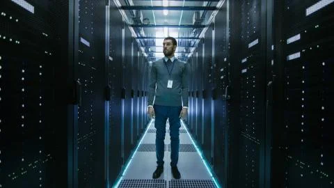 Curios IT Engineer Standing in the Middle of a Working Data Center Server Roo Stock Photos