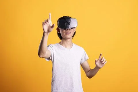 Curious Asian man using VR headset exploring digital simulation Stock Photos