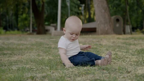 Curious baby exploring nature, touching grass and leaves, discovering textures Stock Footage 315183149