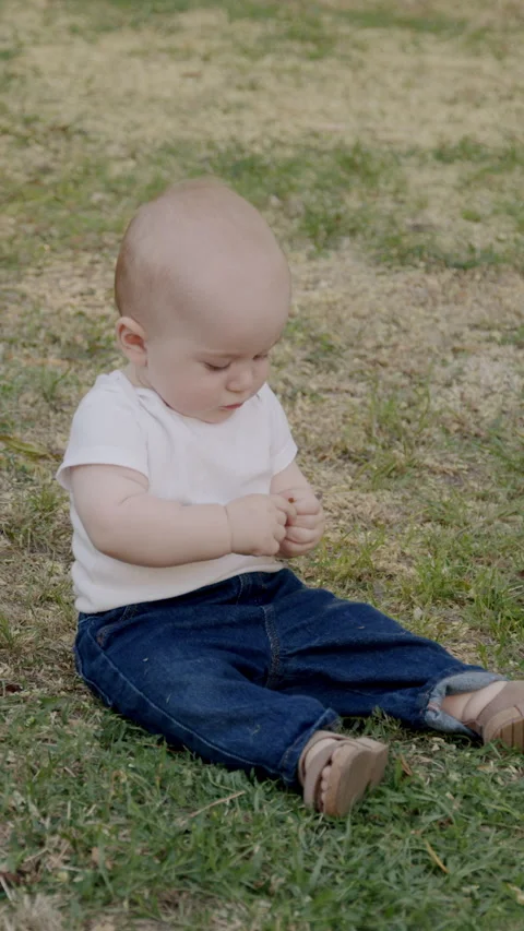 Curious baby exploring nature, touching grass and leaves, discovering textures Stock Footage 317326737