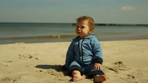 Curious baby sitting at the beach Stock Footage 63142840