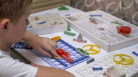 Curious Boy Assembles Electrical Circuit of Metal Construction Kit Parts. 4K Stock Footage 147444476