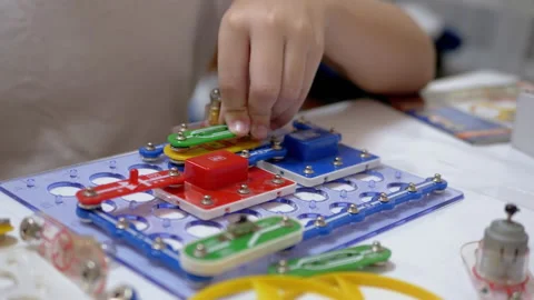 Curious Boy Assembles Electrical Circuit of Metal Construction Kit Parts. 4K Stock Footage 147445938