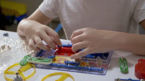 Curious Boy Assembles Electrical Circuit of Metal Construction Kit Parts. 4K Video stock 147448654