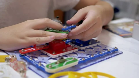 Curious Boy Assembles Electrical Circuit of Metal Construction Kit Parts. 4K Video stock 148990986