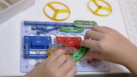 Curious Boy Assembles Electrical Circuit of Metal Construction Kit Parts. 4K Stock Footage 149903039