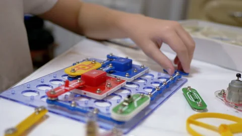 Curious Boy Assembles Electrical Circuit of Metal Construction Kit Parts. 4K Stock Footage 150068879