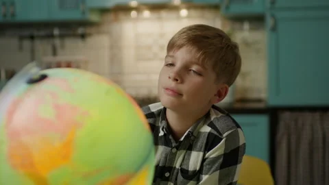 Curious Boy Looking at Earth Globe in Kitchen at Home Stock Footage 345644681