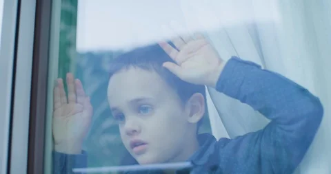 Curious boy looking out of the window 库存影片 102148126