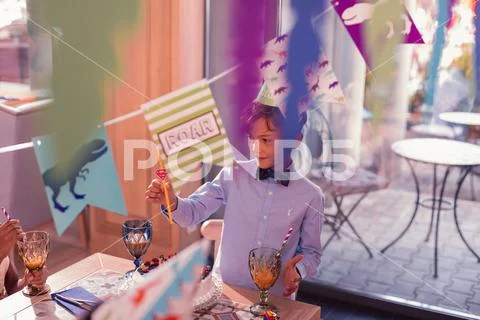 Curious boy looking at the sipping straw while vising interesting party Stock Photos