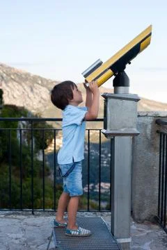 Curious boy, looking through a telescope at something interesting Stock Photos