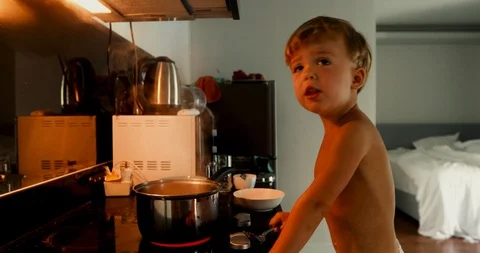 Curious boy standing at cook with steaming pot Stock Footage 103679402