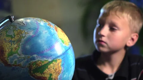 Curious Boy Studying Globe in Classroom Stock Footage 57686030