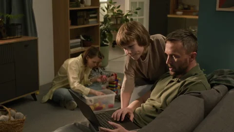Curious Boy Watching Father Writing Code on Laptop while Man Working from Home 스톡 동영상 313752015