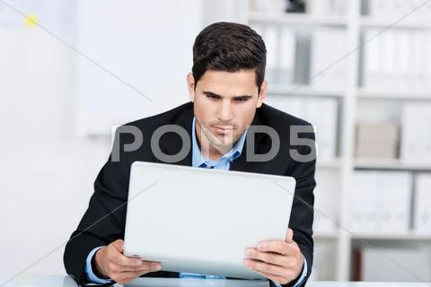 Curious businessman holding laptop Stock Photos