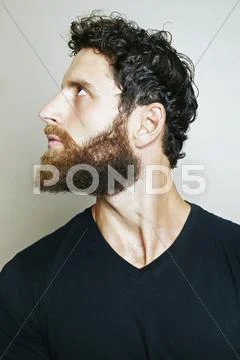Curious Caucasian man with beard looking up Stock Photos