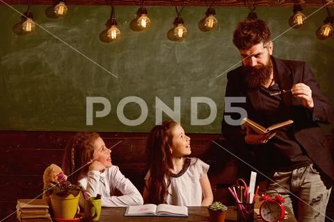 Curious cheerful children listening teacher with attention. Teacher and girls Stock Photos