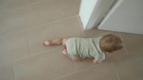 Curious child crawling on tile floor Stock Footage 323885527