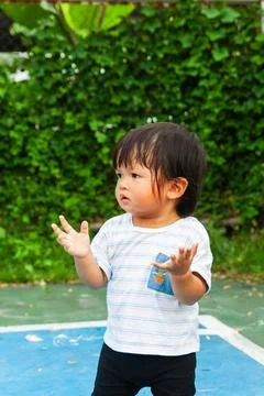 Curious child exploring play area backyard child portrait outdoor eye-level.. Fotos de archivo