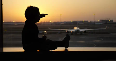 Curious child observing airplane during sunset at airport Stock Footage 303326002