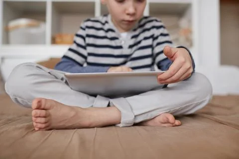 Curious child scrolling on tablet Foto stock