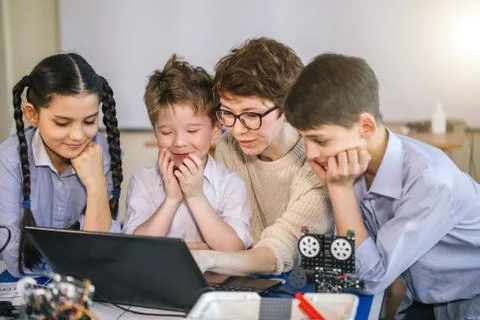Curious children learn programming using laptops on extracurricular classes 库存照片