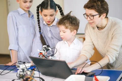 Curious children learn programming using laptops on extracurricular classes Foto stock