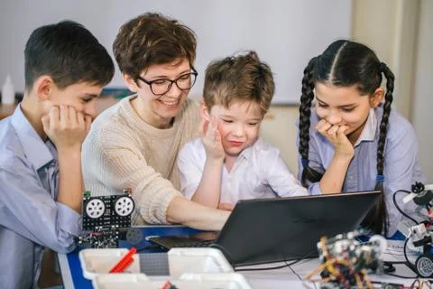 Curious children learn programming using laptops on extracurricular classes Stock Photos