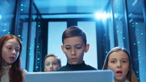 Curious children using a laptop program inside server cabinet, looking excited Stock Footage 121274826