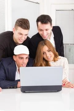 Curious friends looking at laptop computer monitor together Stock Photos