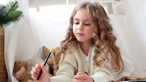 Curious girl deep in thought surrounded by soft toys in a cozy space Stock-Footage 296323735