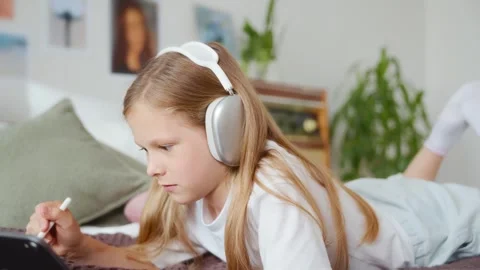 Curious girl drawing on tablet, camera zooms out Stock Footage 312288601