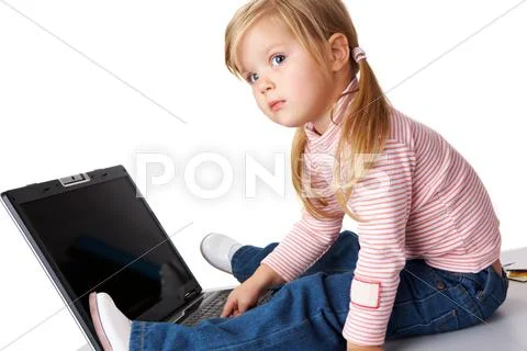 Curious girl sitting in front of laptop and looking aside Stock Photos