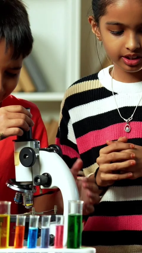 Curious Indian kids using a microscope and test tubes at school Stock Footage 343214465