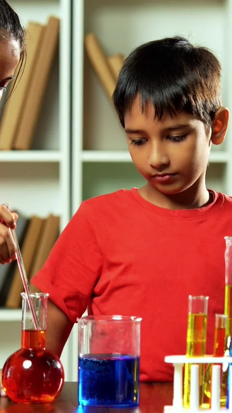 Curious Indian kids using a microscope and test tubes at school Stock Footage 343214474