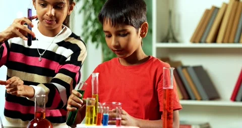 Curious Indian kids using a microscope and test tubes at school Stock Footage 343216092