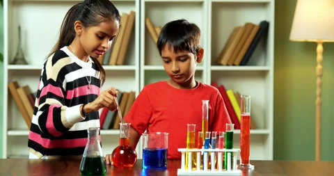 Curious Indian kids using a microscope and test tubes at school Stock Footage 343216124