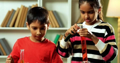 Curious Indian kids using a microscope and test tubes at school Stock Footage 343216222