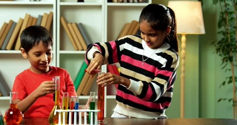 Curious Indian kids using a microscope and test tubes at school Stock Footage 343216238