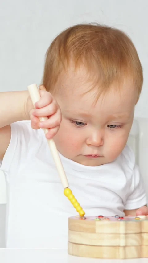 Curious infant boy developing fine motor skills playing with educational wooden Video stock 341284485